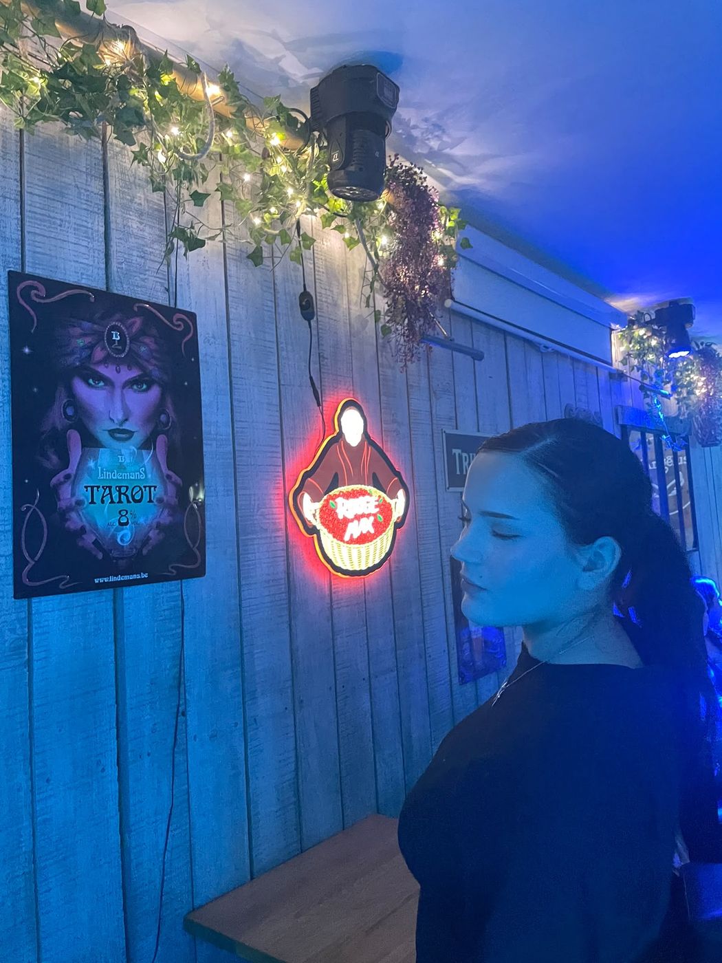 Célia dans un bar décoré de guirlandes lumineuses
