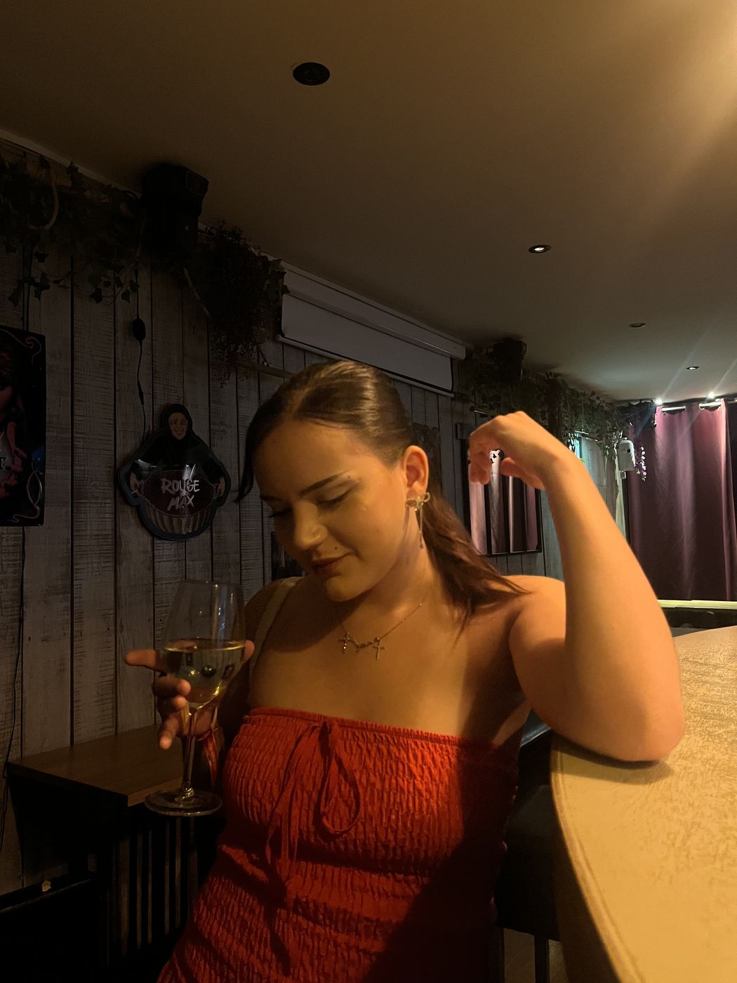 Célia en robe rouge dans un bar